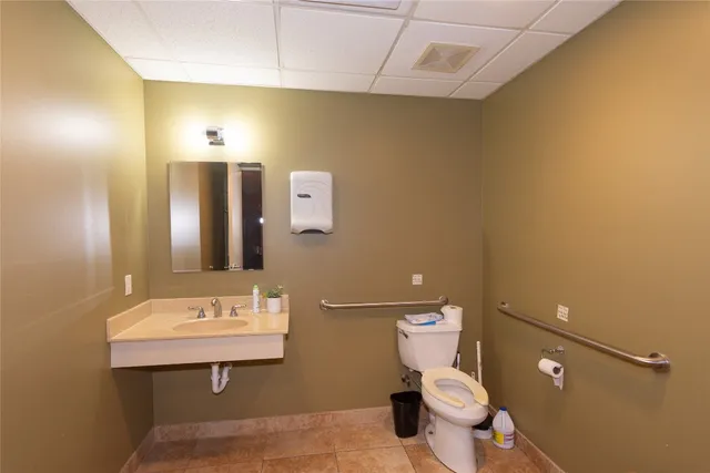 a bathroom with a sink mirror vanity and toilet