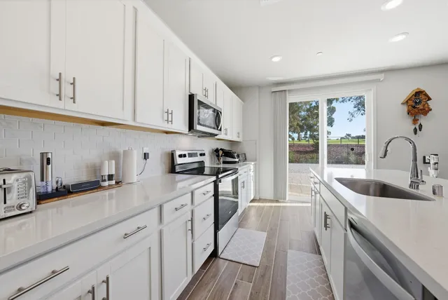 a kitchen with stainless steel appliances granite countertop a sink and a stove