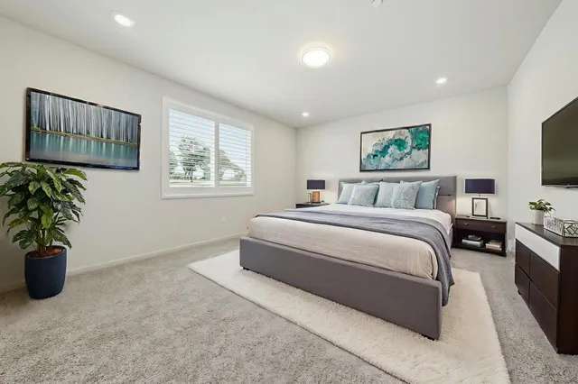 a bedroom with a bed and a potted plant