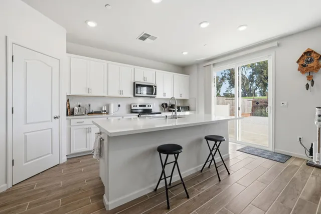 a kitchen with a table chairs microwave and cabinets