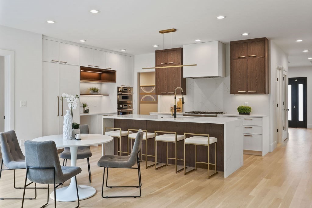108 Bradford Street Needham, MA 02492 - Photo 9 of 42 a kitchen with stainless steel appliances kitchen island granite countertop a table chairs sink and cabinets