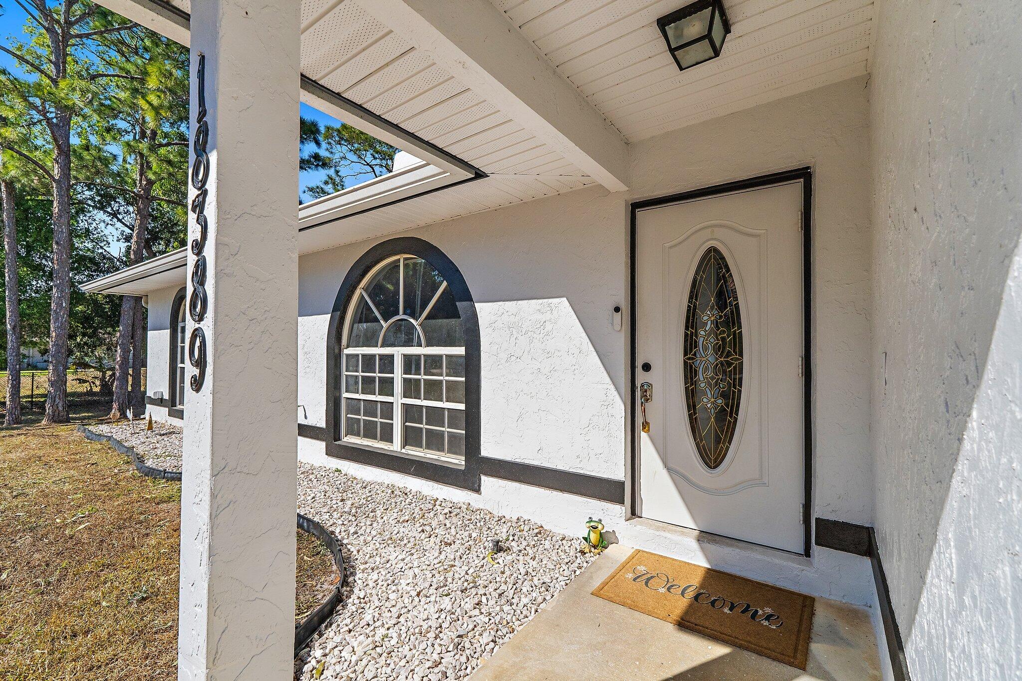 18389 41st Road North Loxahatchee, FL 33470 - Photo 4 of 33 a front view of a house with garden