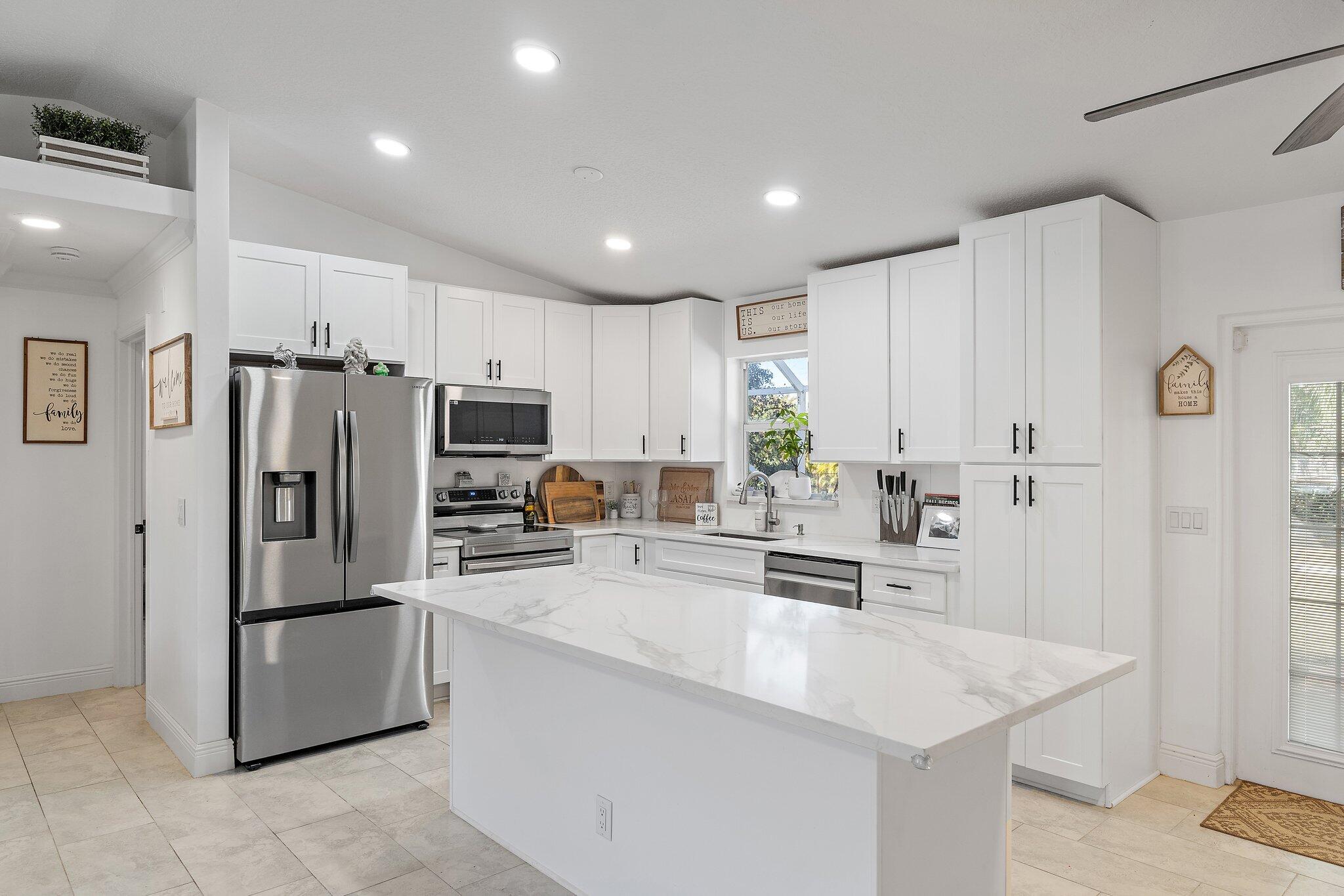 18389 41st Road North Loxahatchee, FL 33470 - Photo 9 of 33 a kitchen with stainless steel appliances granite countertop a refrigerator a stove and a sink