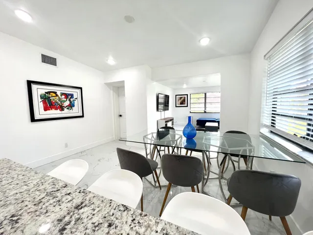 a living room with furniture kitchen view and a window