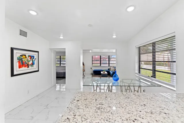 a bathroom with a granite countertop sink a mirror and a toilet