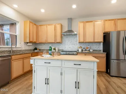 a kitchen with granite countertop white cabinets and refrigerator