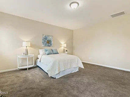 a spacious bedroom with a bed and a cabinets
