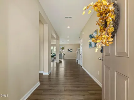 a view of a hallway with wooden floor and a chandelier