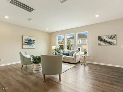 a living room with furniture wooden floor and a large window