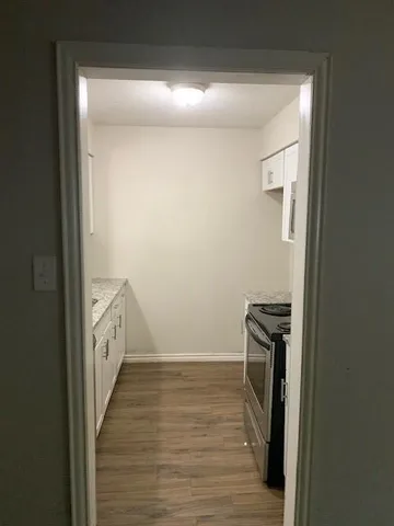 a view of a hallway with wooden floor
