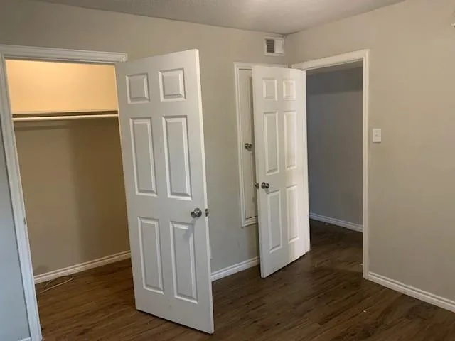 an empty room with wooden floor and a window