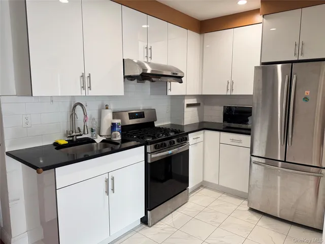 a kitchen with cabinets a sink and stainless steel appliances
