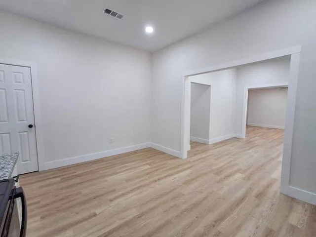 a view of an empty room with wooden floor