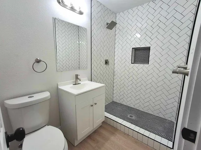 a bathroom with a sink a toilet and shower