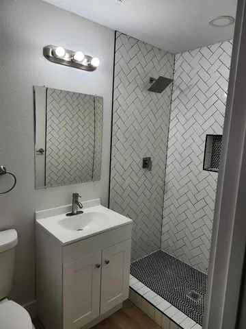 a bathroom with a sink a toilet and shower
