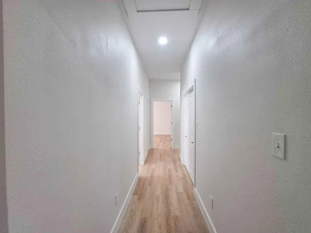 a view of a hallway with wooden floor