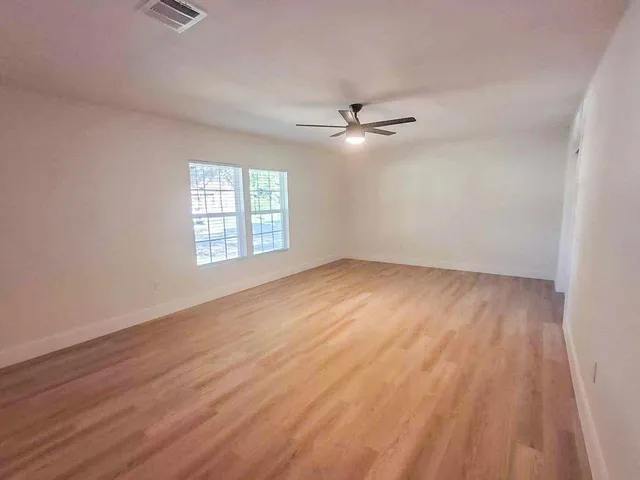 wooden floor in an empty room with a window
