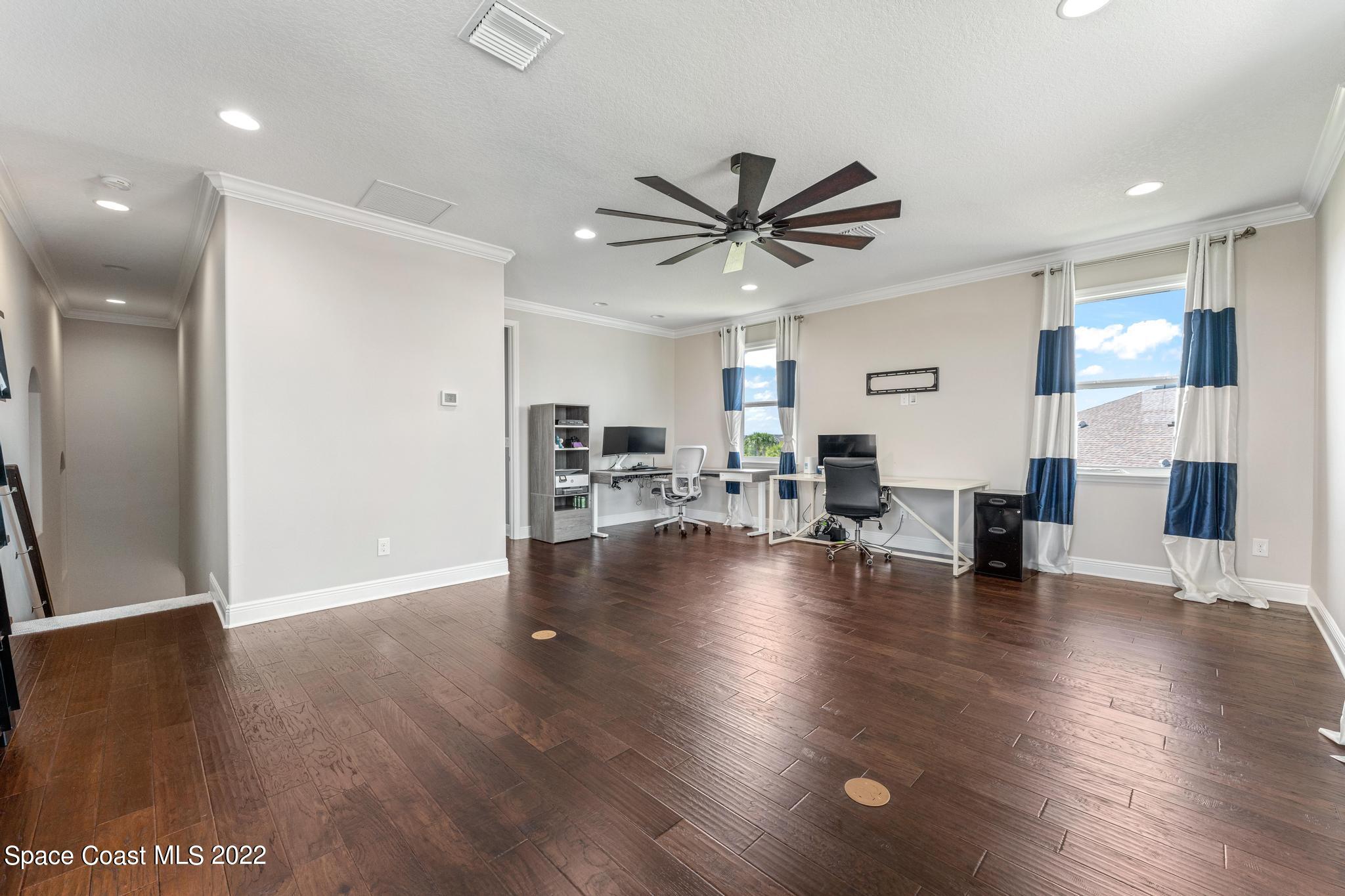 7739 Kerrington Drive Melbourne, FL 32940 - Photo 17 of 35 a view of a livingroom with furniture a ceiling fan and kitchen view
