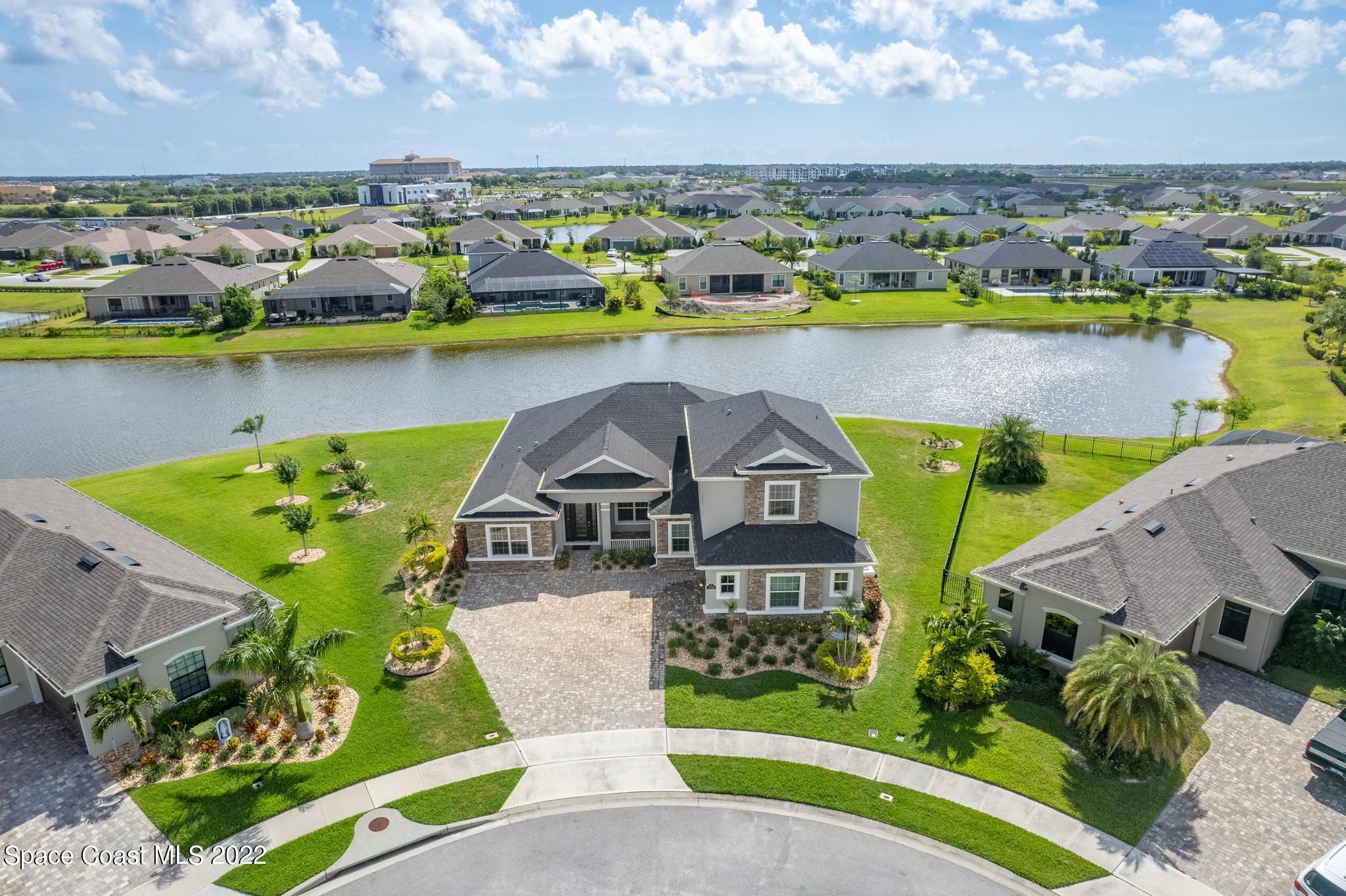 7739 Kerrington Drive Melbourne, FL 32940 - Photo 35 of 35 an aerial view of a house with a swimming pool yard and lake view in back