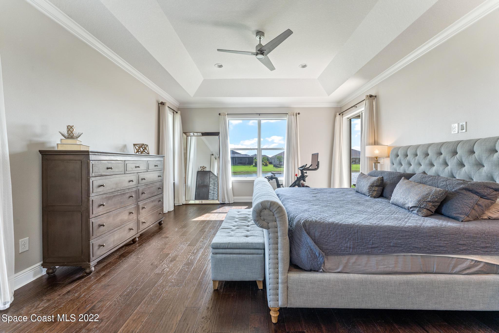 7739 Kerrington Drive Melbourne, FL 32940 - Photo 8 of 35 a bedroom with a bed and wooden floor