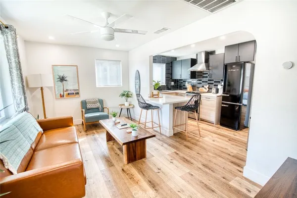 a living room with stainless steel appliances kitchen island furniture a rug kitchen view and a table