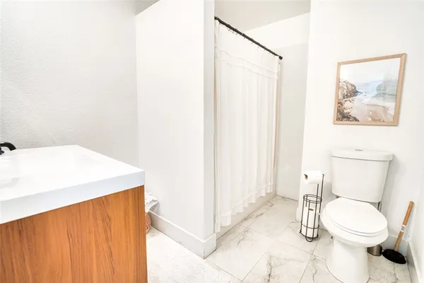 a bathroom with a sink a toilet and a shower curtain
