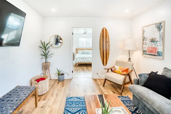 a living room with patio furniture and a wooden floor