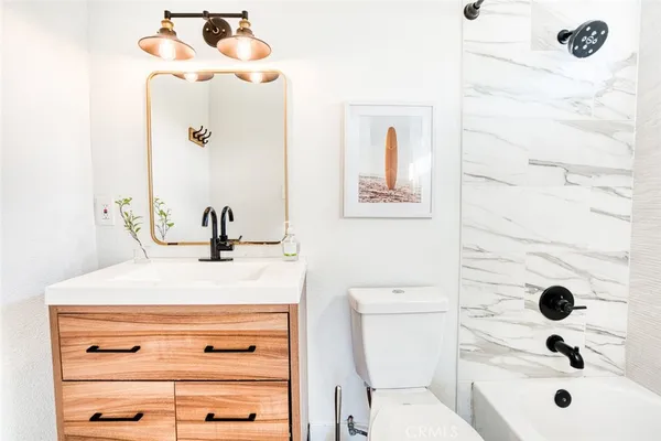 a bathroom with a sink a toilet and a mirror
