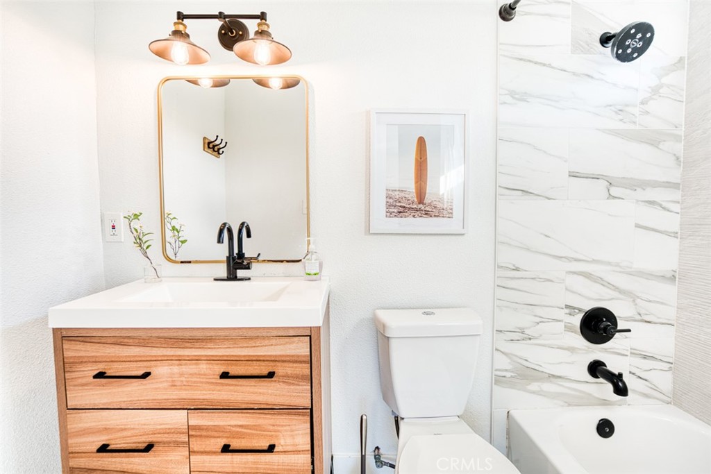 261 North 13th Street Grover Beach, CA 93433 - Photo 36 of 46 a bathroom with a sink a toilet and a mirror