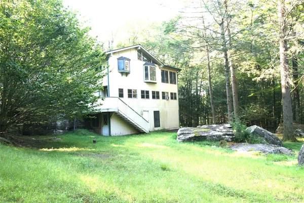 a view of a house with backyard and sitting area
