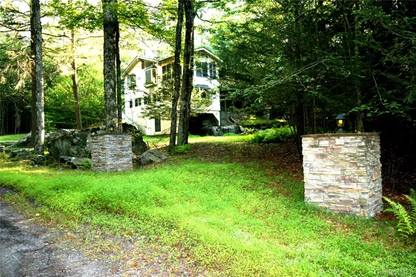 a backyard of a house with plants and large trees
