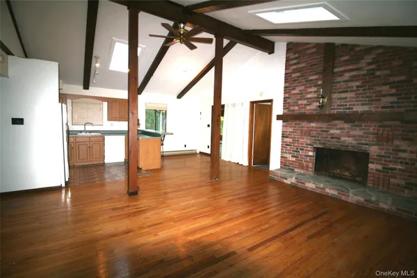 a view of empty room with wooden floor and fireplace