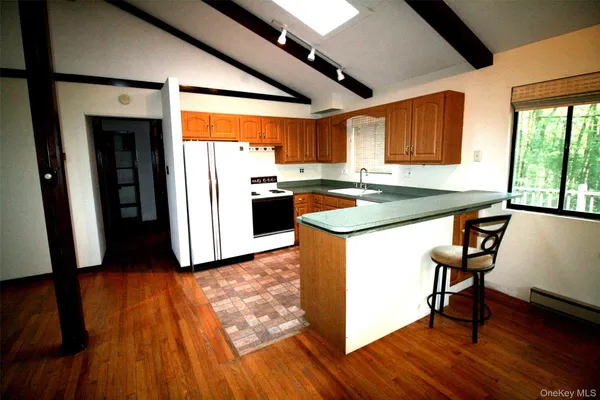 a kitchen with sink a refrigerator and wooden floor