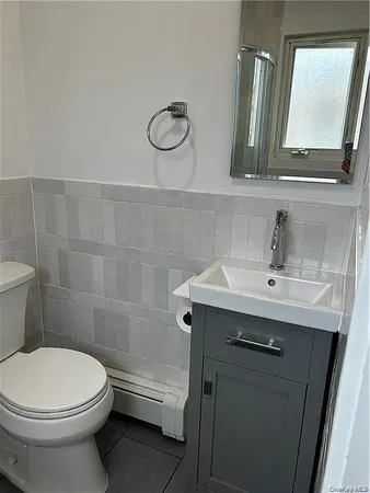 a bathroom with a sink a toilet and mirror
