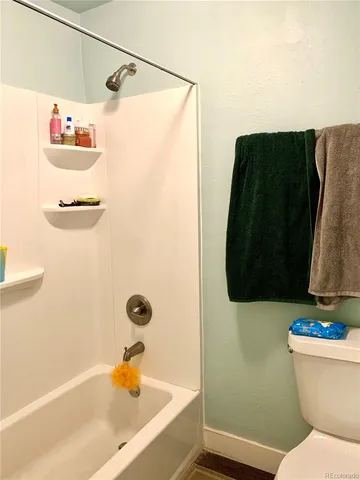 a bathroom with a toilet and a shower curtain