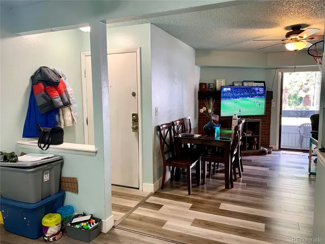 a view of a dining room with furniture one side kitchen view and wooden floor