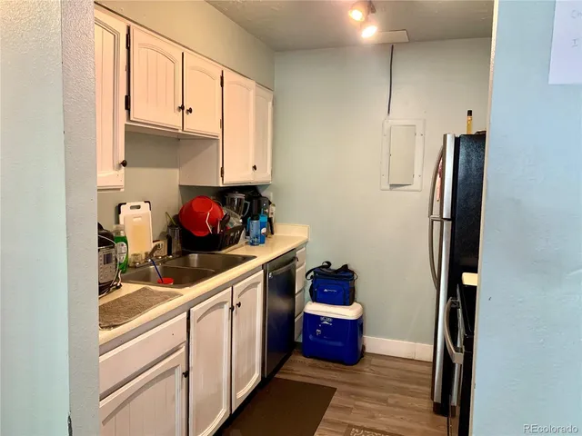 a kitchen with stainless steel appliances granite countertop a refrigerator and white cabinets