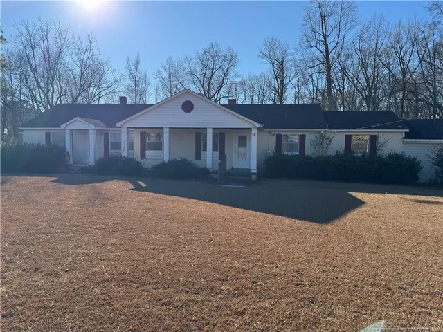 a front view of a house with a yard and trees