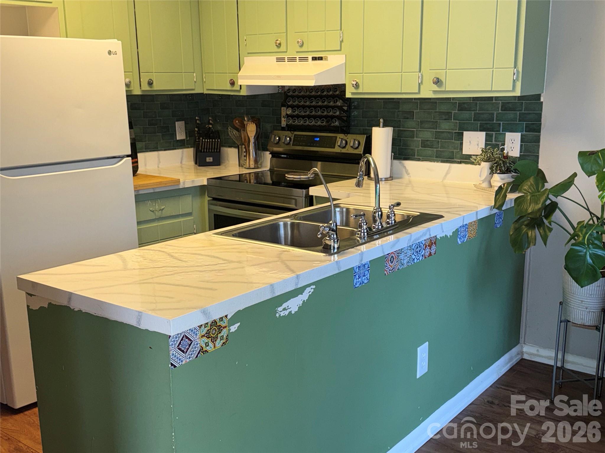 1304 Seaton Road, Unit 15 Durham, NC 27713 - Photo 7 of 20 a view of a kitchen with stainless steel appliances granite countertop a refrigerator a stove and a sink