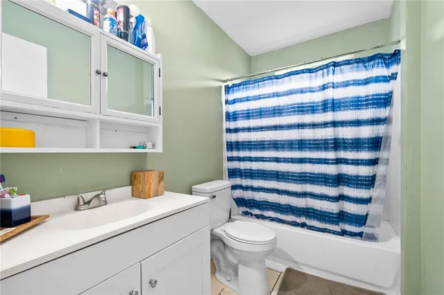 a bathroom with a sink a toilet and shower curtain