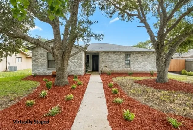 a front view of a house with a yard and an trees