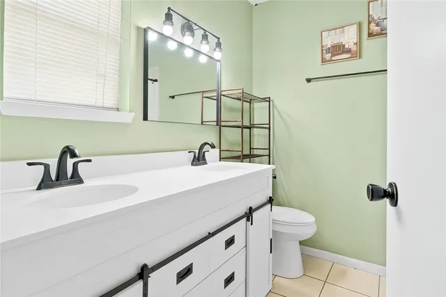 a bathroom with a sink mirror vanity and toilet