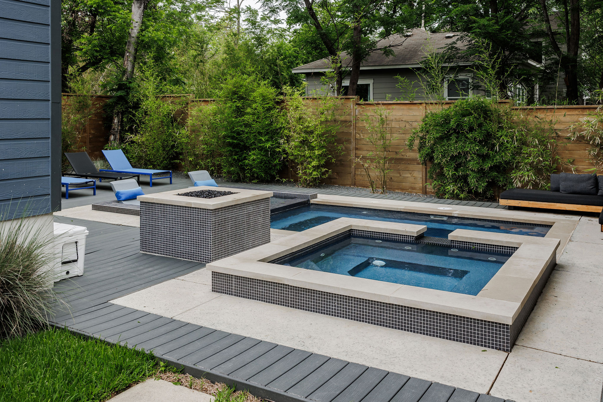 1605 Maple Avenue Austin, TX 78702 - Photo 29 of 33 Outdoor living area featuring a multi-level pool with integrated spa, a fire pit, composite decking, concrete patio, and a wood privacy fence