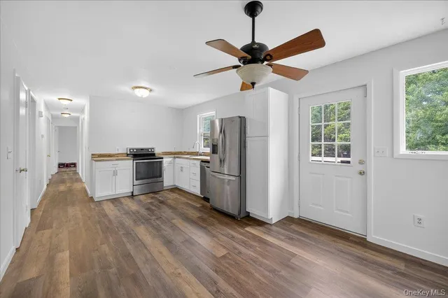 a kitchen with stainless steel appliances a refrigerator and a chandelier