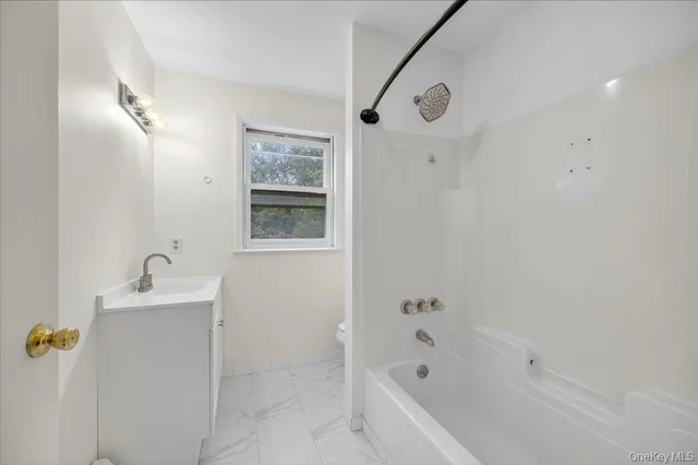 a bathroom with a bathtub sink and mirror