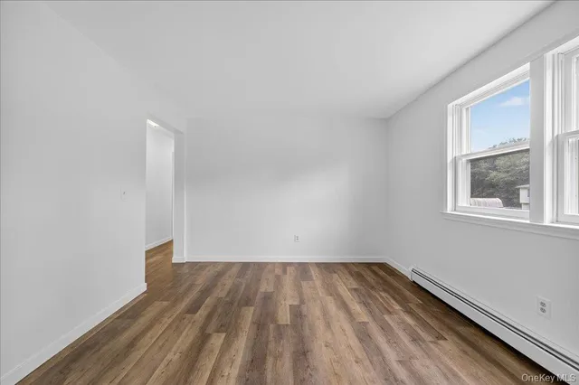 a view of room with window and wooden floor