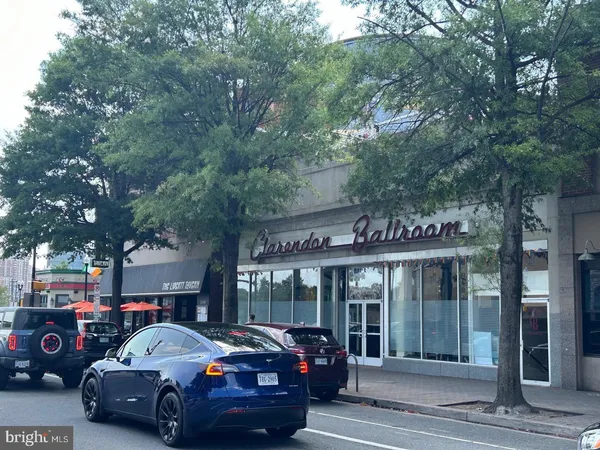 a front view of a building with cars parked