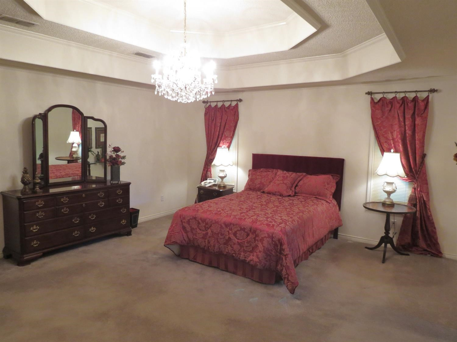 1310 17th Street Ralls, TX 79357 - Photo 8 of 10 a spacious bedroom with a bed and a dresser next to a window
