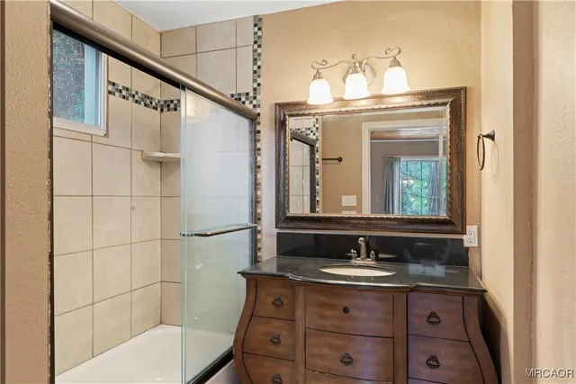 a bathroom with a granite countertop sink a toilet and a mirror