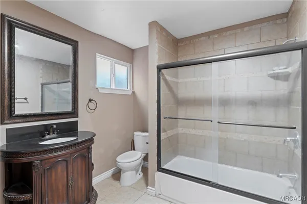 a bathroom with a bathtub shower sink vanity and toilet